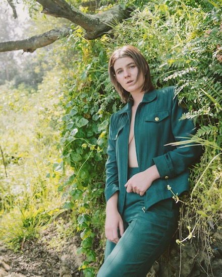 Same green jumpsuit, now there is a wall of green plants involved. And I'm leaning on it.